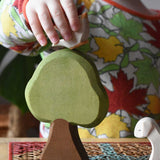 Child placing an Ostheimer dove bird figure on a Linden tree placed in a simple small world play scene.