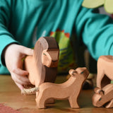Ostheimer small lion cub with head high wooden toy figure placed on a wooden surface with a lion behind. 