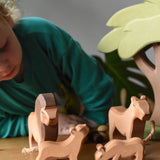 Ostheimer lion family wooden toy figures placed in a small world play scene with an African tree.