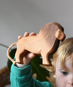 Ostheimer wooden toy lion figure in a child's hand. 