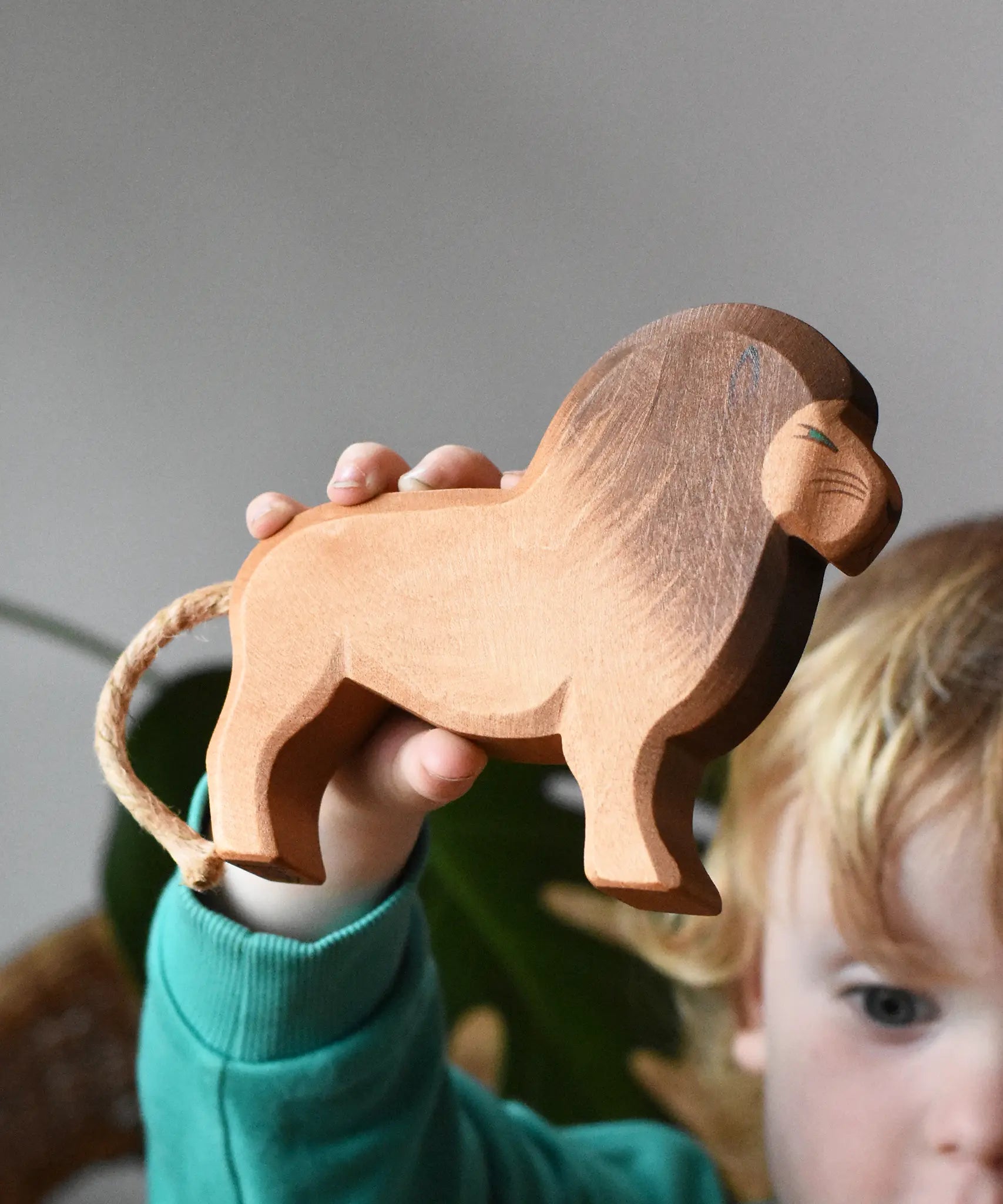 Ostheimer wooden toy lion figure in a child's hand. 