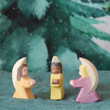 A group of three little wooden angels placed on an Ostheimer pond piece in a small world scene set up. These wooden figures are part of a wide range of expertly hand crafted wooden toys here at Babipur. 