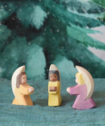 A group of three little wooden angels placed on an Ostheimer pond piece in a small world scene set up. These wooden figures are part of a wide range of expertly hand crafted wooden toys here at Babipur. 
