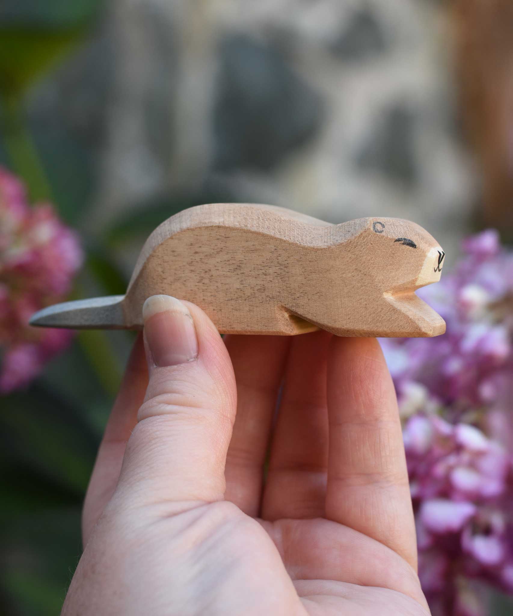 An Ostheimer beaver wooden toy figure, the beaver is in a laying down position. Check out our full range of expertly crafted wooden toy figures and scenery here at Babipur.