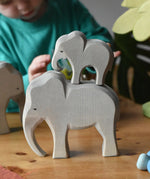 Ostheimer male elephant wooden toy figure with a small eating elephant stacked on top of it. 