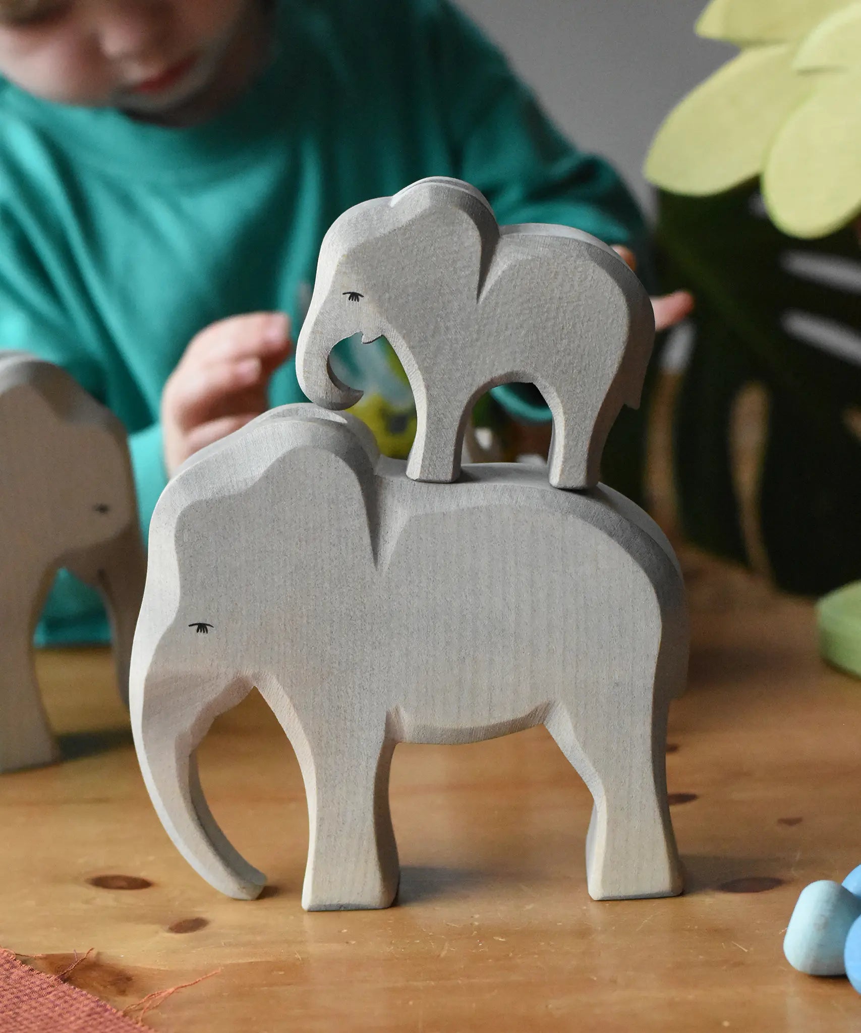Ostheimer male elephant wooden toy figure with a small eating elephant stacked on top of it. 