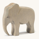 A wooden male Ostheimer elephant figure on a cream background.