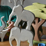 Ostheimer male, female and small eating wooden toy figures stacked on top of each other.
