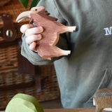 Ostheimer brown male goat wooden toy figure in a child's hand. 