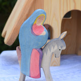 An Ostheimer Mary on donkey wooden toy figure placed in front od the fairy tale house. These wooden figures are part of a large range of expertly hand crafted, Waldorf inspired, wooden toys here at Babipur. 
