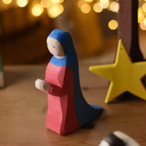 Ostheimer Mary wooden toy figure in a festive small world play scene with fairy lights in the background.