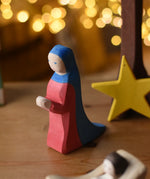 Ostheimer Mary wooden toy figure in a festive small world play scene with fairy lights in the background.