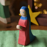Ostheimer Mary wooden toy figure in a festive small world play scene with fairy lights in the background.