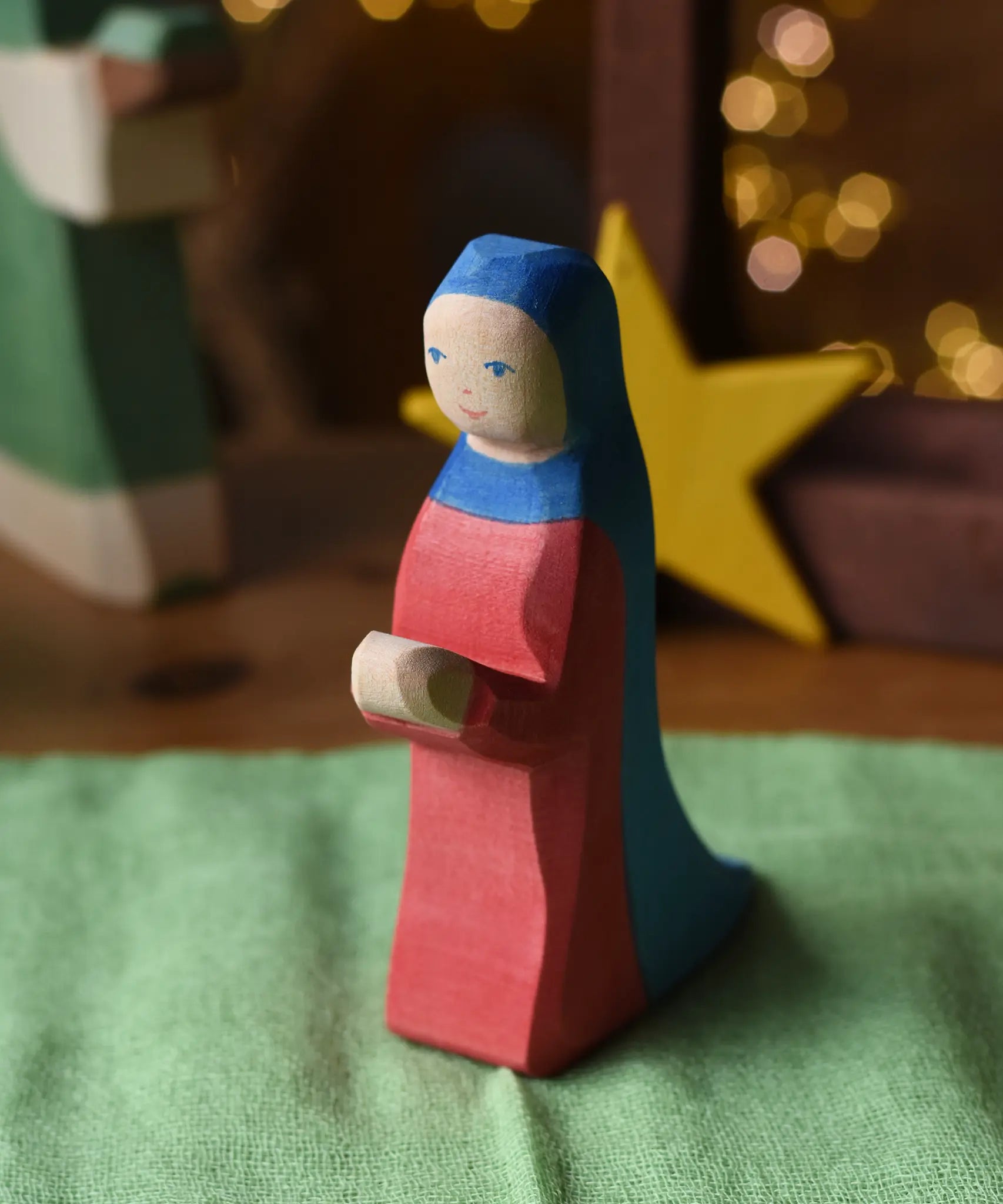 Ostheimer Mary wooden toy figure in a festive small world play scene with fairy lights in the background.
