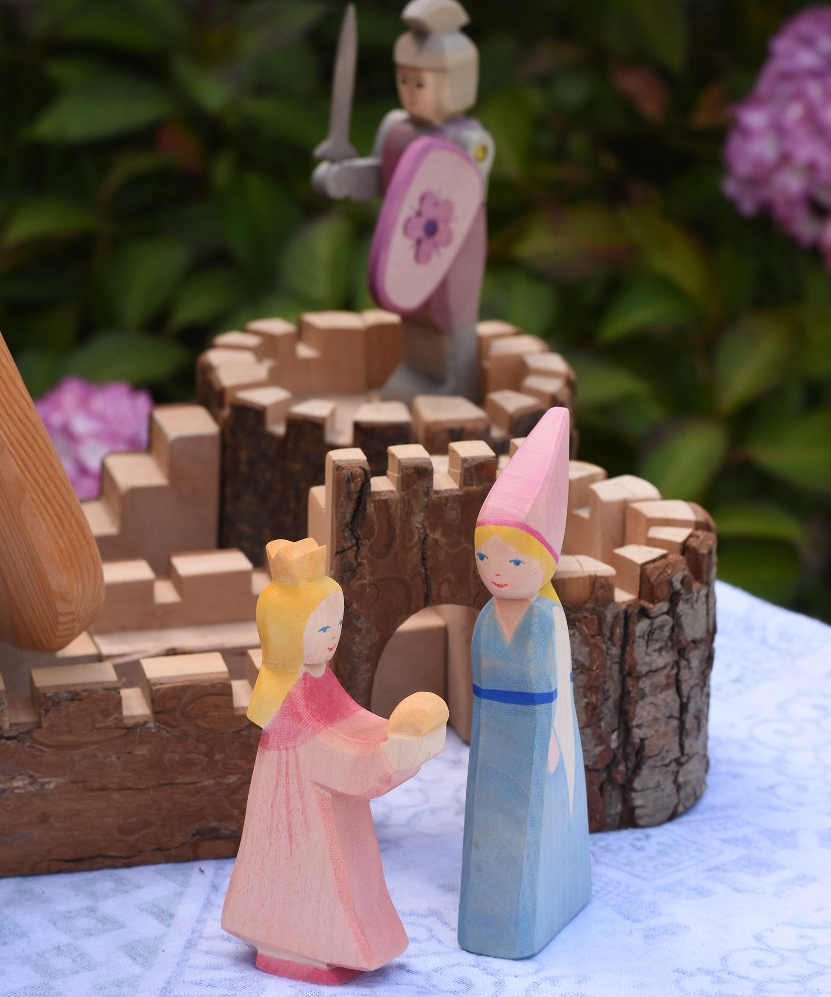 Two Ostheimer wooden princess figures placed in front of the Magic Wood castle. These wooden figures are part of a large range of expertly and crafted, Waldorf inspired, wooden toys here at Babipur. 