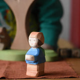 Ostheimer Mo handmade little boy wooden toy figure placed on a brown cloth.
