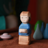 Ostheimer Mo handmade wooden toy figure. Little boy with brown trousers, blue top and a brown hat.