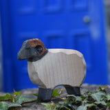 An Ostheimer wooden ram figure placed on a stone wall outdoors. These wooden figures are part of a large range of expertly hand crafted, Waldorf inspired, wooden toys here at Babipur.
