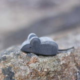 An Ostheimer tiny wooden mouse placed on a stone wall outdoors. Check out our full range of expertly crafted wooden toy figures and scenery here at Babipur.