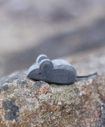 An Ostheimer tiny wooden mouse placed on a stone wall outdoors. Check out our full range of expertly crafted wooden toy figures and scenery here at Babipur.