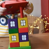 Child placing the red roof on the Ostheimer multi coloured block house.