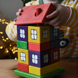 Child lifting the roof off the Ostheimer multi coloured block house.