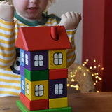 Ostheimer multi coloured block house stacker toy. Child cheering in the background.