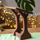 Ostheimer wooden nativity manger with roof placed on a green cotton play cloth.