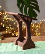 Ostheimer wooden nativity manger with roof placed on a green cotton play cloth.