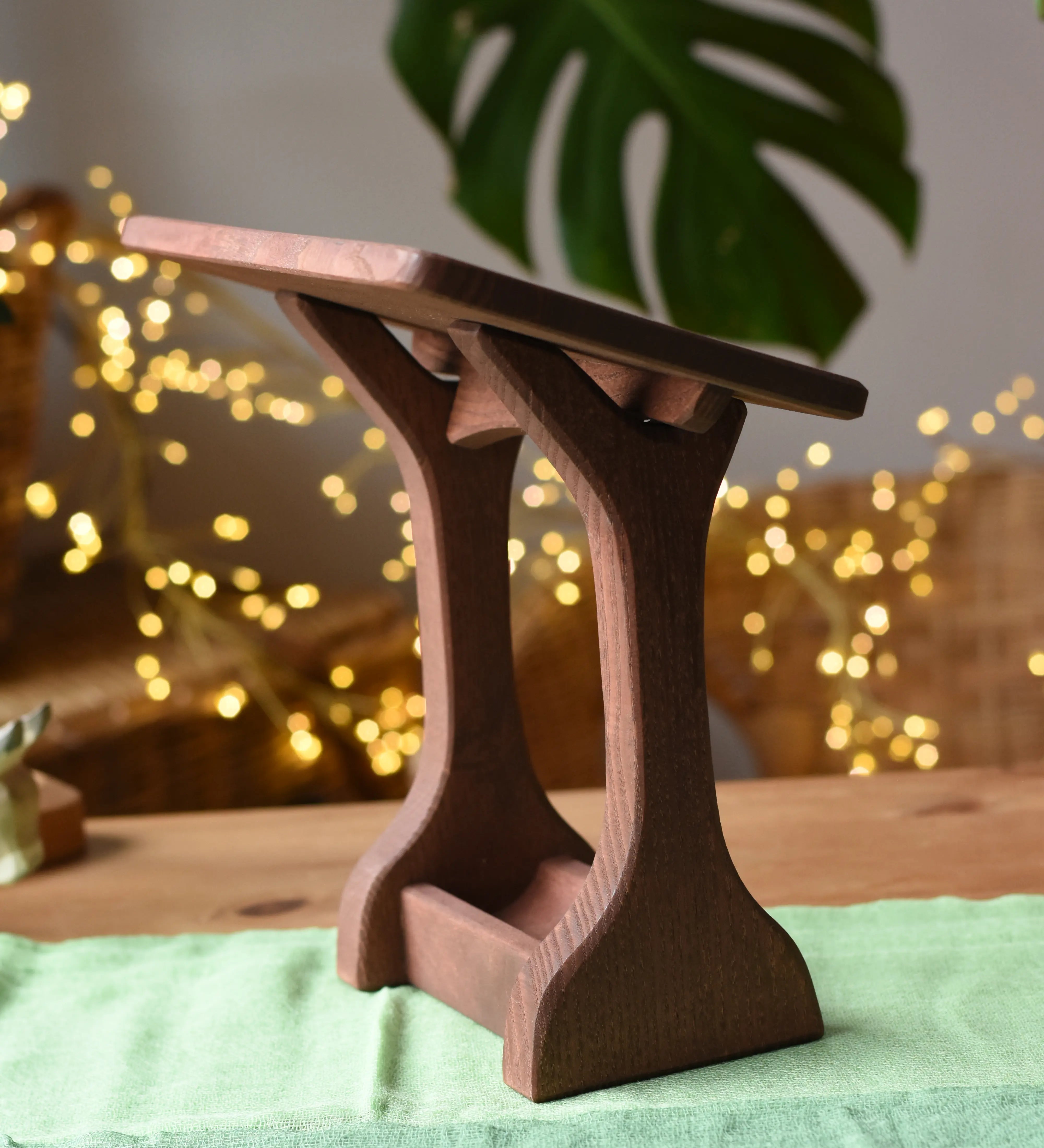 Ostheimer wooden nativity manger with roof placed on a green cotton play cloth.