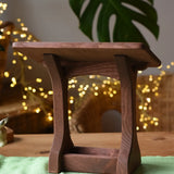 Ostheimer wooden nativity manger with roof placed on a green cotton play cloth.