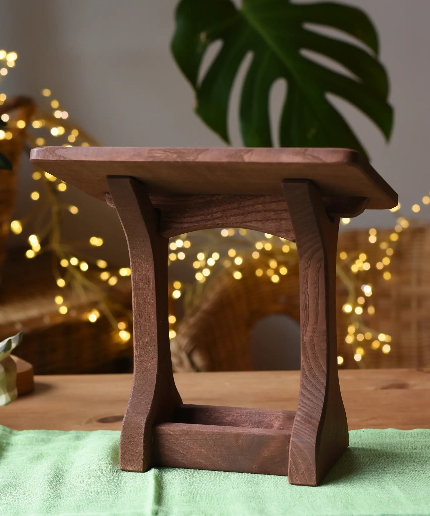 Ostheimer wooden nativity manger with roof placed on a green cotton play cloth.