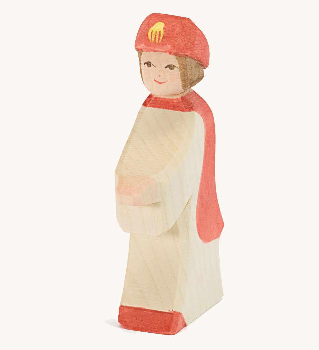 Ostheimer Red King’s Page wooden nativity figure, a Waldorf inspired Star Singer with white skin and brown hair, wearing a white robe with a red cloak and red hat, hand madefrom natural wood