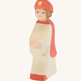 Ostheimer Red King’s Page wooden nativity figure, a Waldorf inspired Star Singer with white skin and brown hair, wearing a white robe with a red cloak and red hat, hand madefrom natural wood