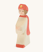 Ostheimer Red King’s Page wooden nativity figure, a Waldorf inspired Star Singer with white skin and brown hair, wearing a white robe with a red cloak and red hat, hand madefrom natural wood