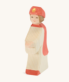 Ostheimer Red King’s Page wooden nativity figure, a Waldorf inspired Star Singer with white skin and brown hair, wearing a white robe with a red cloak and red hat, hand madefrom natural wood