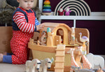 A child playing with the The Ostheimer Noah's ark and ship's cabin There are lots of Ostheimer wooden animals on and around the ark.
