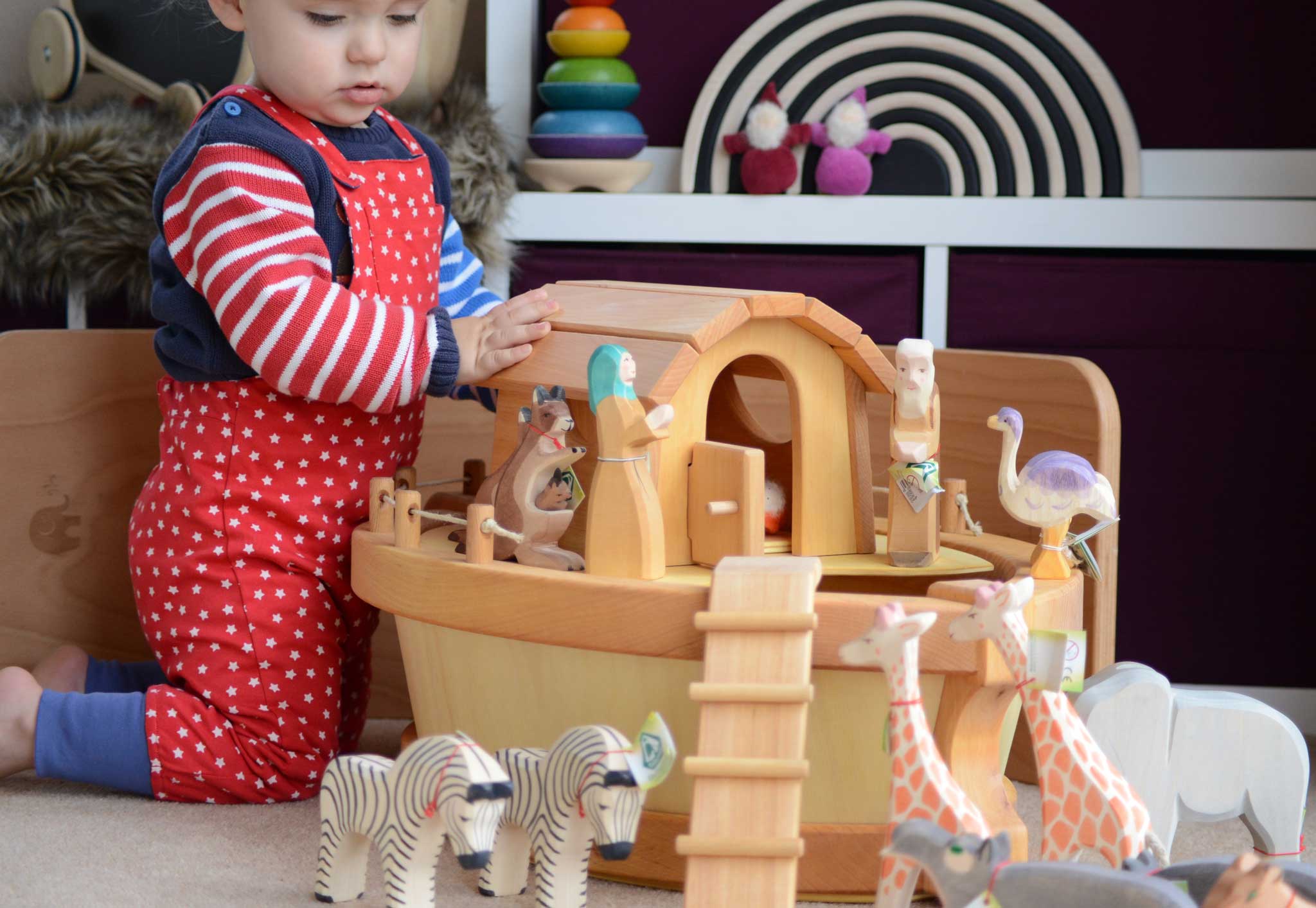 A child playing with the The Ostheimer Noah's ark and ship's cabin There are lots of Ostheimer wooden animals on and around the ark.
