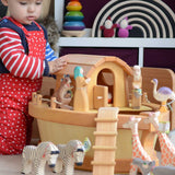 A child playing with the The Ostheimer Noah's ark and ship's cabin There are lots of Ostheimer wooden animals on and around the ark.
