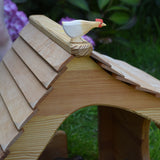 An Ostheimer hen with long neck standing on the roof of an Ostheimer cottage. These wooden figures are part of a large range of expertly hand crafted, Waldorf inspired, wooden toys here at Babipur. 
