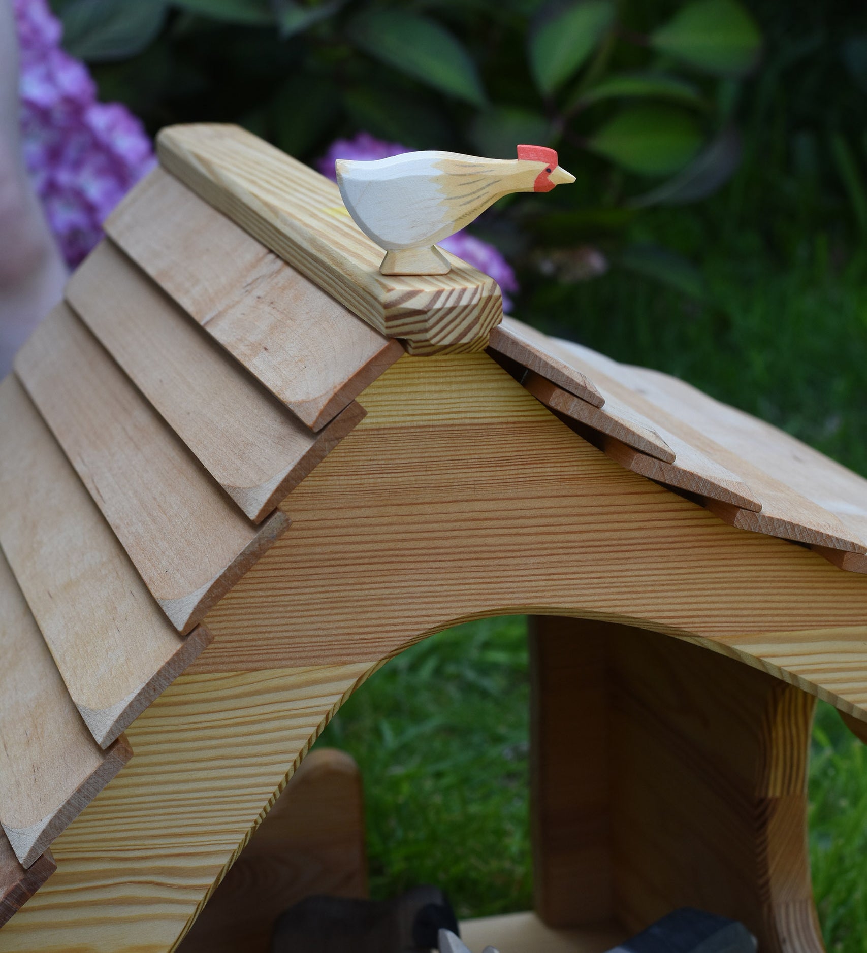 An Ostheimer hen with long neck standing on the roof of an Ostheimer cottage. These wooden figures are part of a large range of expertly hand crafted, Waldorf inspired, wooden toys here at Babipur. 
