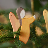 Ostheimer orange angel wooden handmade decoration placed on a Christmas tree branch. 