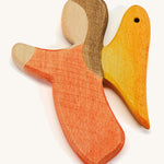 a orange wooden angel figure on a cream background