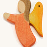 a orange wooden angel figure on a cream background