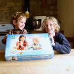 Two children smiling and holding up the Ostheimer paint your own creative set. The set is in it's packaging. 