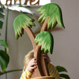 Ostheimer palm tree group with support base being held up in the air by a child.