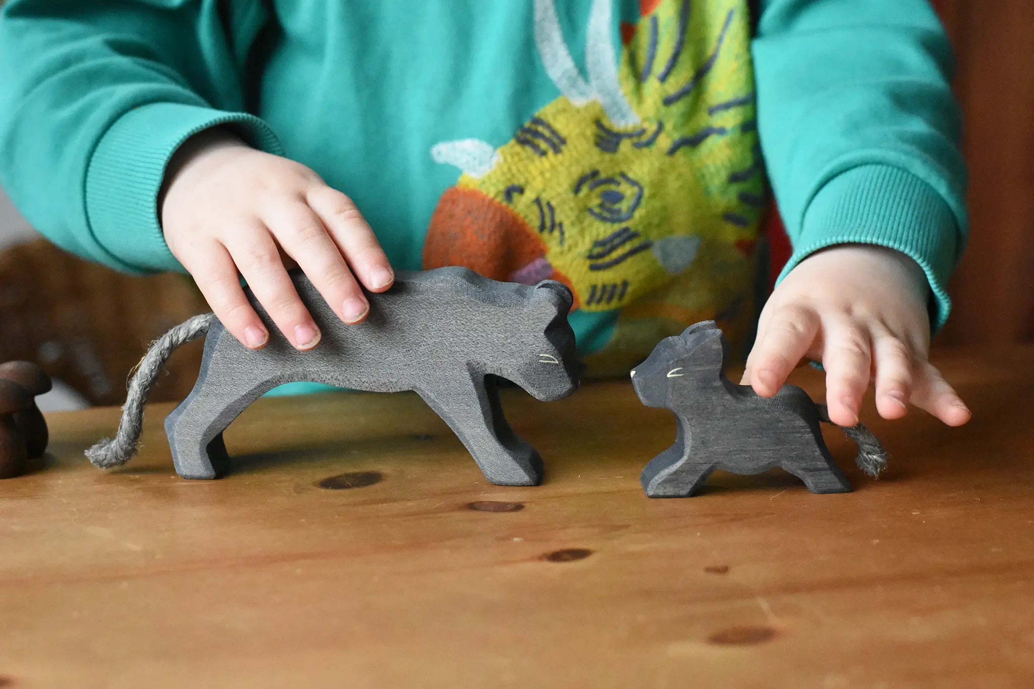 Child playing with the Ostheimer black panther handmade wooden toy figures.