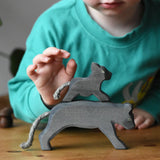Ostheimer small running panther wooden toy figure placed on the back of a large one. 