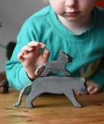 Ostheimer small running panther wooden toy figure placed on the back of a large one. 