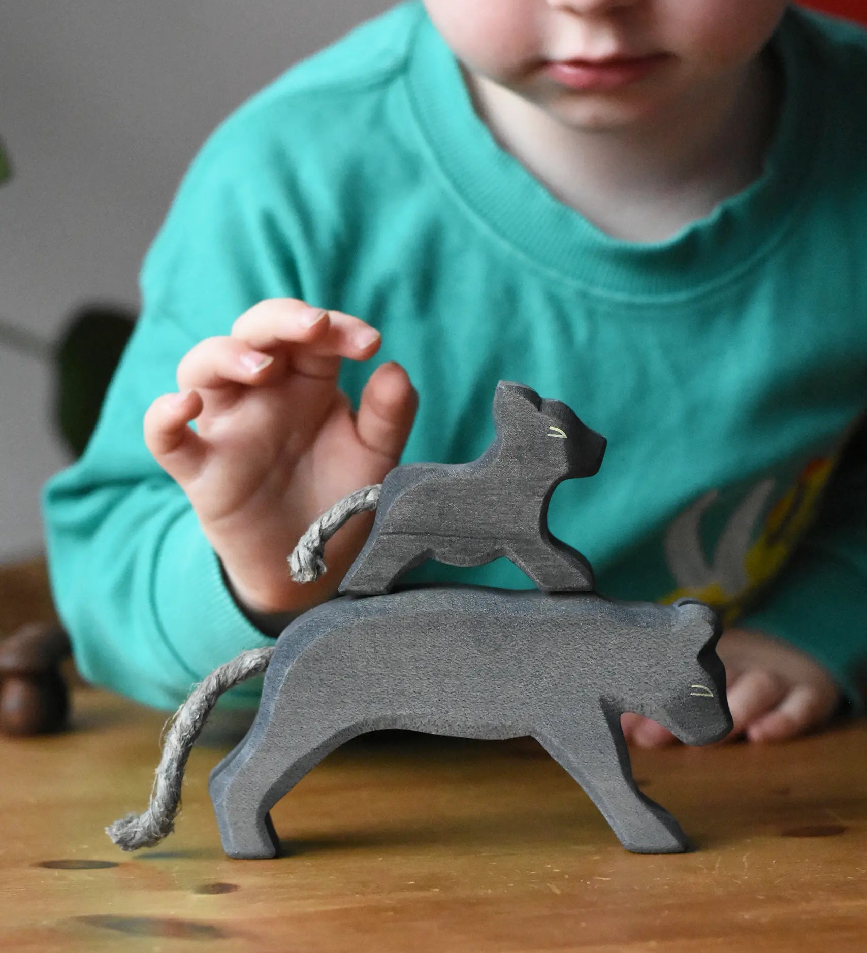 Ostheimer small running panther wooden toy figure placed on the back of a large one. 